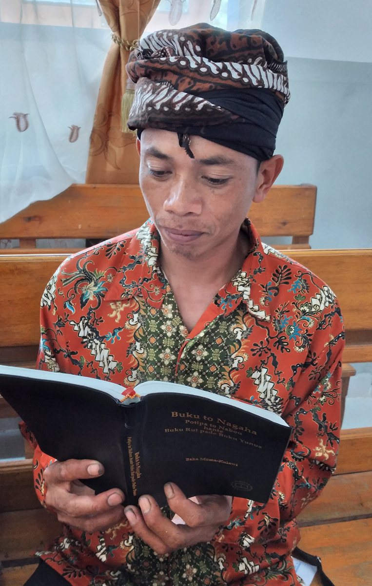 Image of a Moma man reading his Moma New Testament