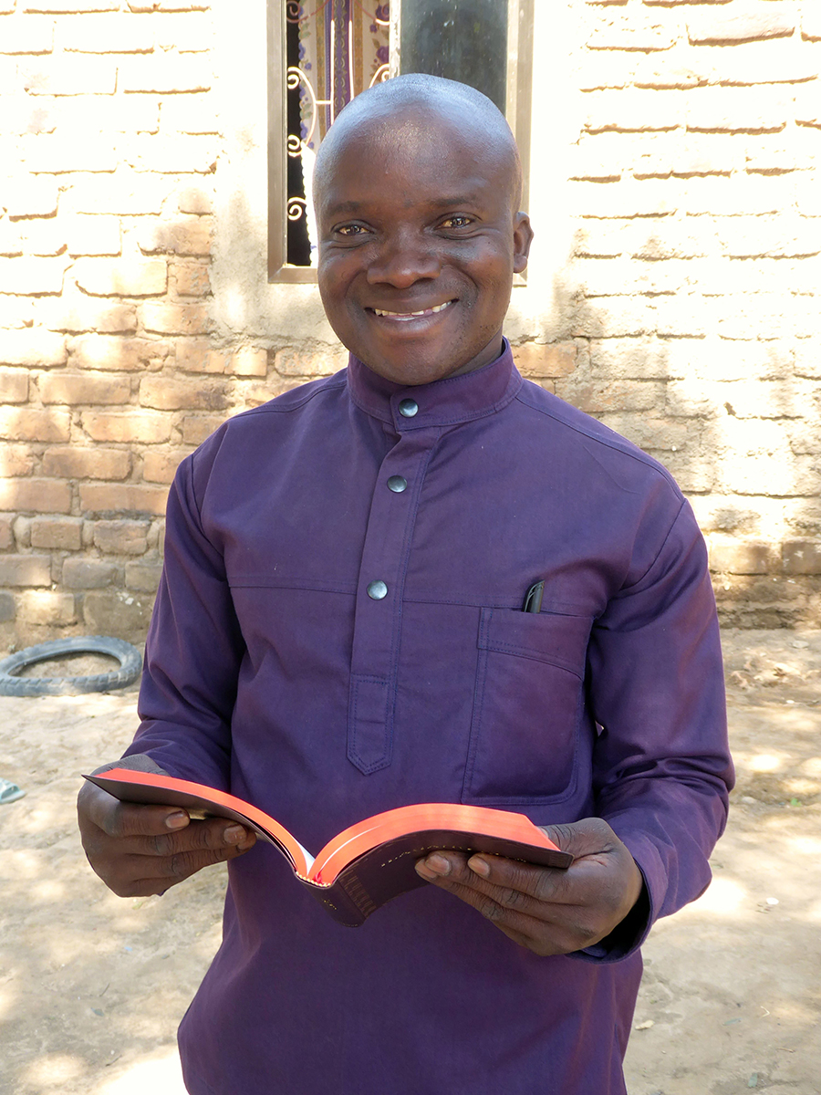 Image of Amani Mwandezi holding the Safwa New Testament at the launch event