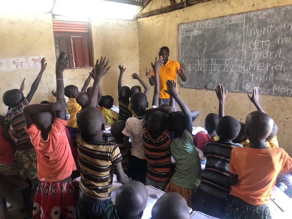 Image of Pokot children excited to answer a question during a school class