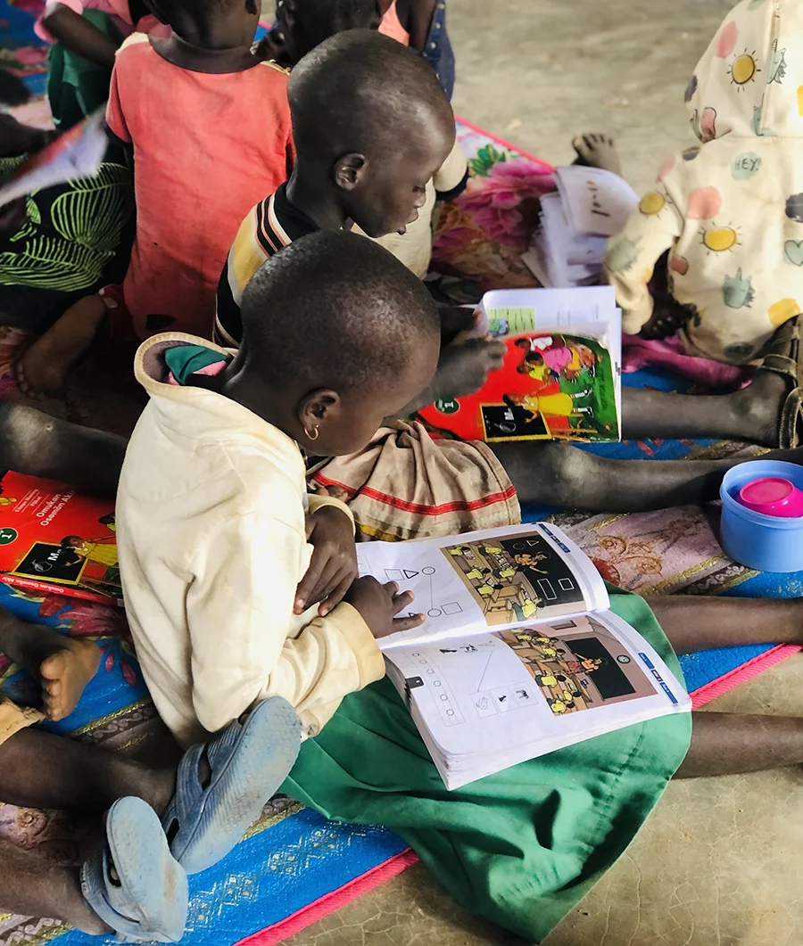 Image of Pokot children looking at school books written in the Pokot language