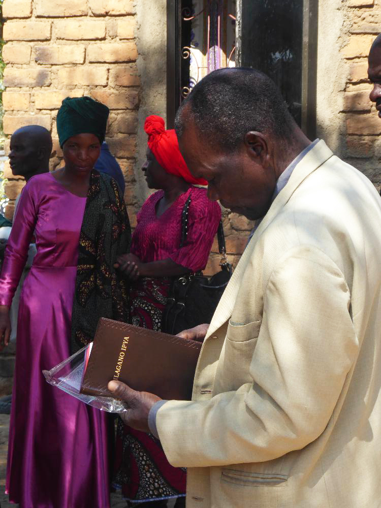 Image of a man reading his newly launched Safwa New Testament