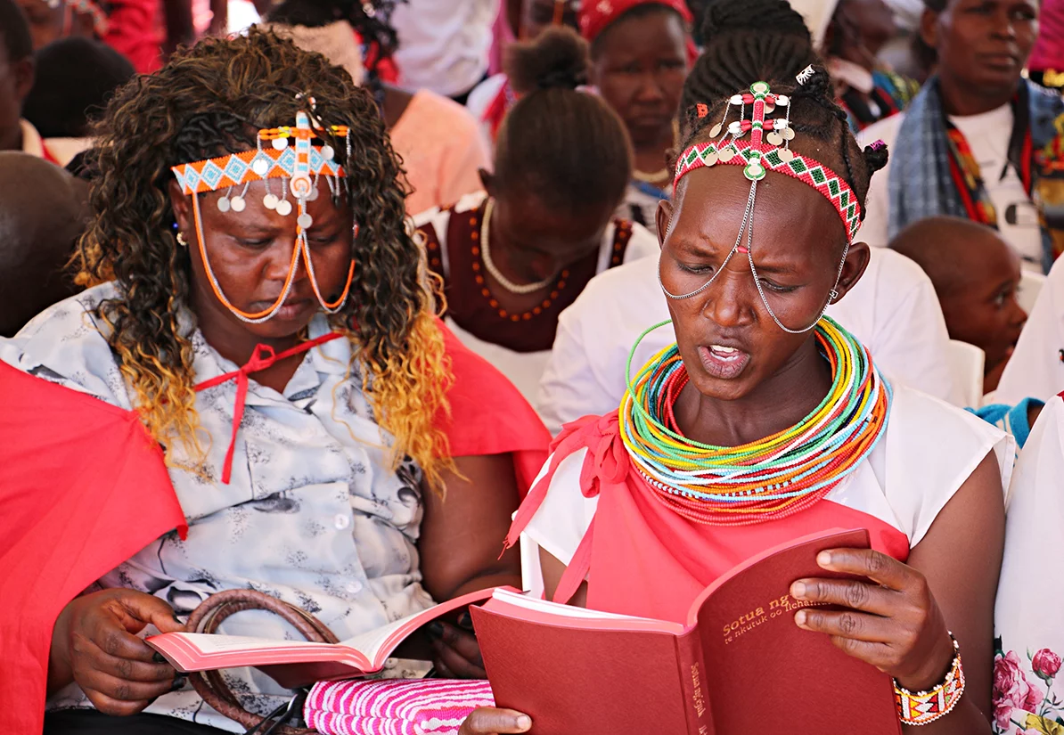 Image of two Ilchamus women reading their Ilchamus New Testament