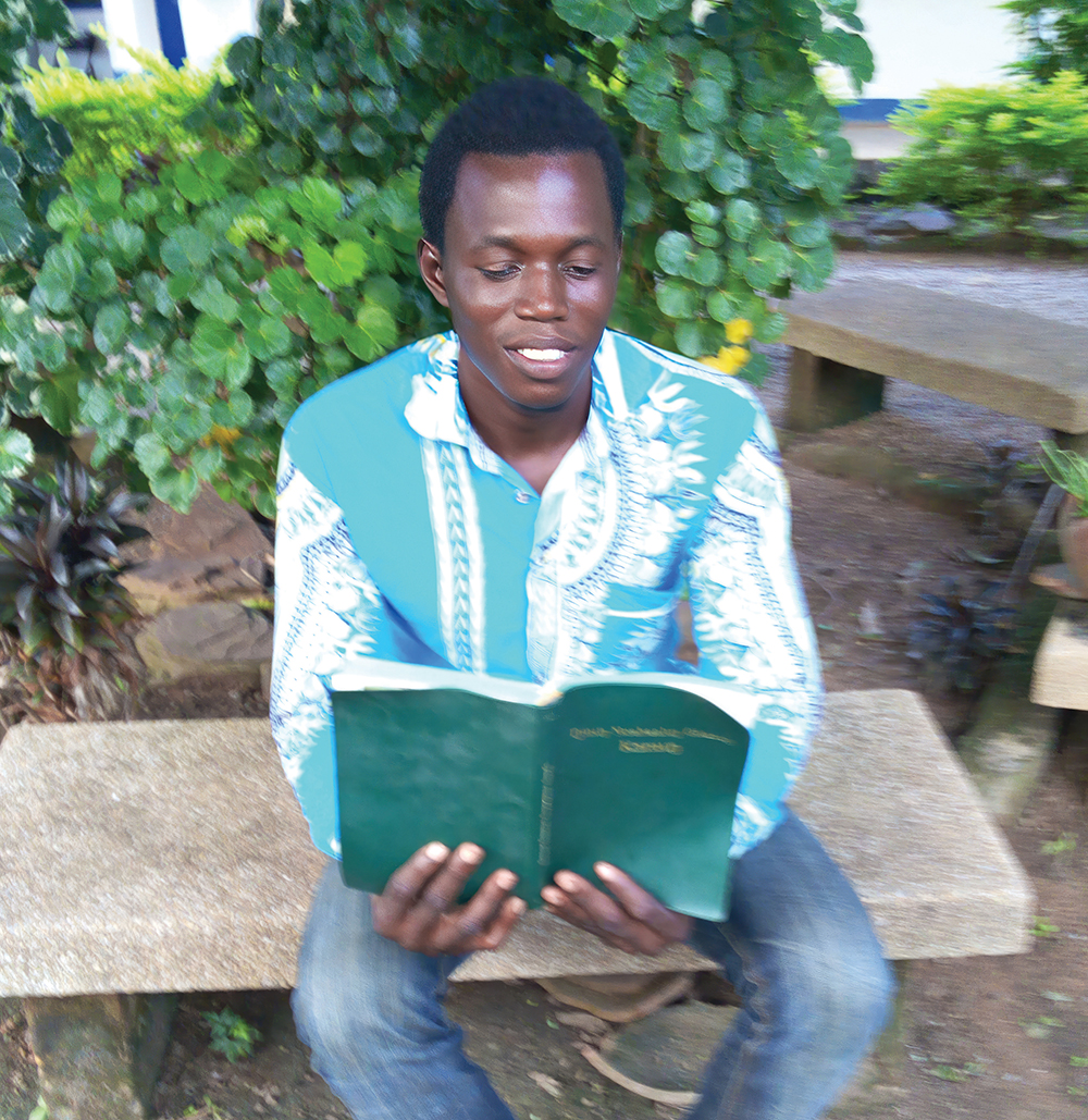 Image of Laminu, a Koma pastor in Ghana, reading the Koma New Testament