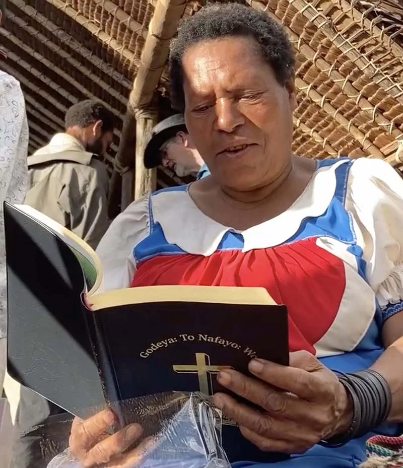 Image of a Kaluli woman reading her newly launched New Testament