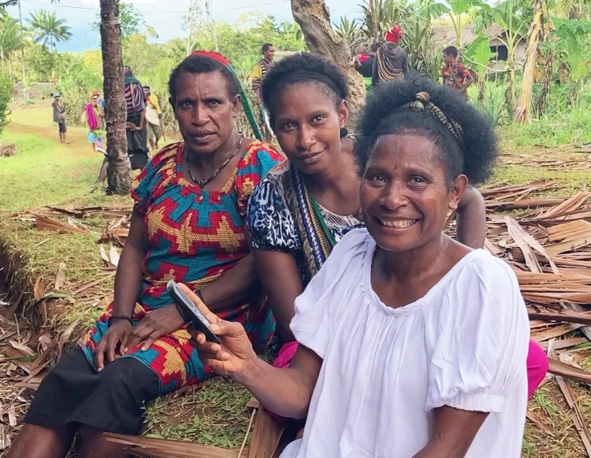 Image of three Kaluli women listening to the audio version of the Kaluli New Testament