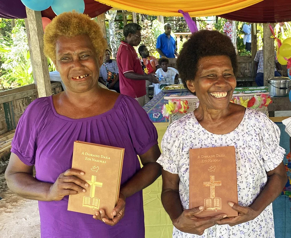Image of two Nalik women holding their New Testaments at the launch event