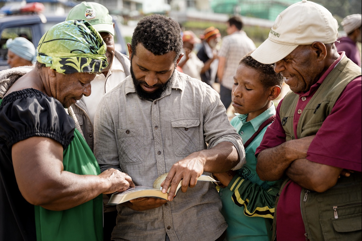 Image of people study the Enga New Testament together