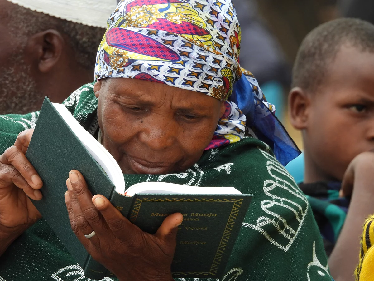 Image of a woman intently studying the Rangi New Testament at its launch