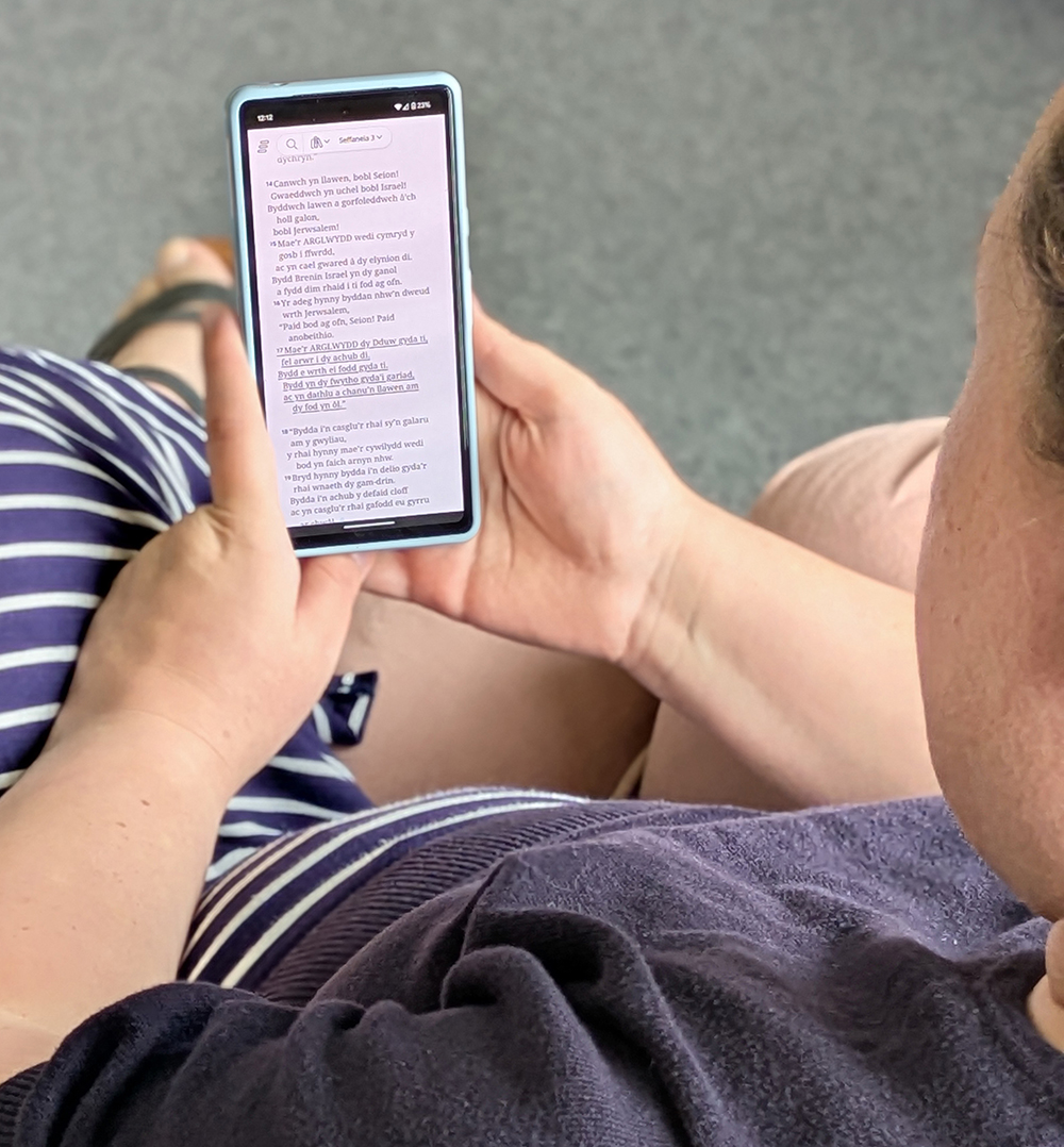Image of Lowri Turner reading her Welsh Bible app