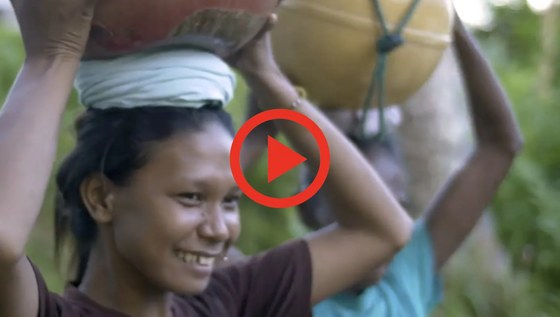 Image of a Dobel woman with a pot on her head